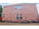 Back exterior of a brick two story home showcasing windows and manicured landscaping at 480 Glenns Farm Way, Grayson, GA 30017