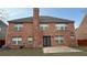 An exterior view of the two-story home featuring a red brick facade, chimney, and backyard at 480 Glenns Farm Way, Grayson, GA 30017