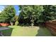 Fenced backyard with manicured lawn, trees, and concrete patio at 480 Glenns Farm Way, Grayson, GA 30017