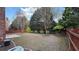 A spacious backyard featuring a wooden fence, greenery, and a concrete patio at 480 Glenns Farm Way, Grayson, GA 30017