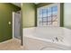Bright bathroom featuring a soaking tub with tiled surround and separate shower at 480 Glenns Farm Way, Grayson, GA 30017