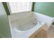 Bathroom featuring white tub with tile backsplash, faucet, and a window at 480 Glenns Farm Way, Grayson, GA 30017