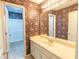 Well-lit bathroom featuring floral wallpaper, a vanity with a mirror, and a shower/tub combination at 480 Glenns Farm Way, Grayson, GA 30017