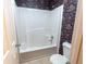 Bathroom with white tub and shower, toilet, and floral wallpaper at 480 Glenns Farm Way, Grayson, GA 30017