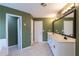 Bathroom featuring double sinks, white cabinetry, tile flooring, and olive-colored walls at 480 Glenns Farm Way, Grayson, GA 30017