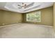 Bright bedroom with a tray ceiling, carpeted floors, and large windows offering outdoor views at 480 Glenns Farm Way, Grayson, GA 30017