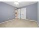 Cozy bedroom with a ceiling fan, carpet, and a door leading to a bathroom at 480 Glenns Farm Way, Grayson, GA 30017