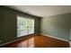 Bedroom features hardwood floors, neutral paint, and a large window that provides plenty of natural light at 480 Glenns Farm Way, Grayson, GA 30017