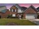 Charming two-story brick home with well-manicured lawn and attached two-car garage at 480 Glenns Farm Way, Grayson, GA 30017