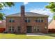 Brick home with tall chimney overlooking green backyard and patio at 480 Glenns Farm Way, Grayson, GA 30017