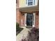 Close-up of the front door with a glass insert and sidelights, set in a brick facade and lovely landscaping at 480 Glenns Farm Way, Grayson, GA 30017