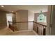 Upstairs hallway featuring a wooden railing, carpet flooring, and natural light from a window at 480 Glenns Farm Way, Grayson, GA 30017