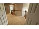 Upstairs hallway featuring a wooden railing and carpet flooring leading to bedrooms at 480 Glenns Farm Way, Grayson, GA 30017