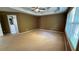 Open main bedroom with tan carpet, tray ceiling, and an ensuite bathroom at 480 Glenns Farm Way, Grayson, GA 30017