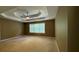 Spacious main bedroom featuring a tray ceiling with ceiling fan and a large window at 480 Glenns Farm Way, Grayson, GA 30017