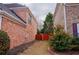 Side yard between two brick homes showing a red wooden fence and some trimmed shrubs at 480 Glenns Farm Way, Grayson, GA 30017