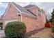 Brick side of the home with neat landscaping and greenery next to a stained wood fence at 480 Glenns Farm Way, Grayson, GA 30017