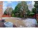 Backyard with partial snow cover, a small concrete patio, wooden fence, and mature trees at 480 Glenns Farm Way Way, Grayson, GA 30017