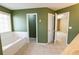 Bright bathroom features a soaking tub with a large window and neutral-colored tile at 480 Glenns Farm Way Way, Grayson, GA 30017