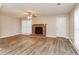 Inviting living room with wood-look floors, brick fireplace, and bright windows at 4893 Autumn Cir, Stone Mountain, GA 30088