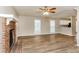 Spacious living room featuring a brick fireplace, wood-look floors, and a ceiling fan at 4893 Autumn Cir, Stone Mountain, GA 30088