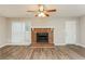 Comfortable living room with wood-look floors, a cozy brick fireplace, and a ceiling fan at 4893 Autumn Cir, Stone Mountain, GA 30088