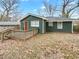View of the backyard and wooden deck with green siding, a brown door, and white trim at 136 Victor Nw Cir, Atlanta, GA 30314