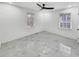 Airy bedroom with modern ceiling fan, bright white walls, and glossy gray tile flooring under two windows at 136 Victor Nw Cir, Atlanta, GA 30314