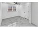 Cozy bedroom with white walls, modern ceiling fan, marble-patterned floors, and natural light from the window at 136 Victor Nw Cir, Atlanta, GA 30314