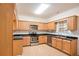 Modern kitchen with wooden cabinets, stainless steel appliances, and black countertops at 140 Whimsical Ct, Locust Grove, GA 30248