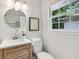 Bright bathroom featuring a round mirror, wood vanity, and modern fixtures at 1943 Main Nw St, Atlanta, GA 30318