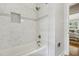 Sleek bathroom with a tub, shower and bright marble tile at 1943 Main Nw St, Atlanta, GA 30318