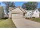 Inviting beige brick home with a two-car garage, professionally landscaped yard, and cozy front entryway at 2208 Croghan Dr, Hampton, GA 30228