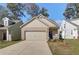 Inviting beige brick home with a two-car garage, professionally landscaped yard, and cozy front entryway at 2208 Croghan Dr, Hampton, GA 30228