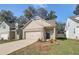 Inviting beige brick home with a two-car garage, professionally landscaped yard, and cozy front entryway at 2208 Croghan Dr, Hampton, GA 30228