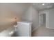 Upstairs hallway with neutral walls, carpeted floor, chandelier, and door leading to another room at 2208 Croghan Dr, Hampton, GA 30228