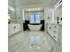 A modern bathroom featuring double vanities, a soaking tub and marble floors at 3499 Lake Mill Rd, Buford, GA 30519
