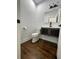 Charming powder room with dark wood floors and a modern vanity at 3499 Lake Mill Rd, Buford, GA 30519
