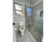 Modern bathroom features a glass-enclosed shower and a toilet with a window view at 3499 Lake Mill Rd, Buford, GA 30519