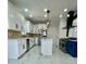 Modern kitchen with white cabinets, stainless steel appliances, island, and stylish lighting at 3499 Lake Mill Rd, Buford, GA 30519