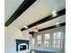 Sunny living room featuring exposed beams, a fireplace, and large windows at 3499 Lake Mill Rd, Buford, GA 30519