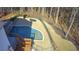 Aerial view of a backyard pool featuring beautiful stonework, landscaping, and mature trees at 3499 Lake Mill Rd, Buford, GA 30519