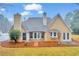 Inviting back exterior featuring a tan siding, white trim, a stone patio, and a well-manicured lawn at 221 The Esplanade Se Way, Loganville, GA 30052