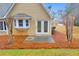 Back patio with glass patio door, well-maintained lawn, and view of a tree-lined yard at 221 The Esplanade Se Way, Loganville, GA 30052