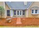 Backyard patio area with brick path, bird bath, and view of a tree-lined yard at 221 The Esplanade Se Way, Loganville, GA 30052