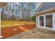 Backyard patio area with glass patio door, brick path, and view of a tree-lined yard at 221 The Esplanade Se Way, Loganville, GA 30052