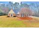 Charming front exterior displaying a manicured lawn, brick accents, neutral siding, and a welcoming entrance at 221 The Esplanade Se Way, Loganville, GA 30052