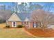 Charming brick home with a landscaped front yard, beautiful lawn, and mature trees at 221 The Esplanade Se Way, Loganville, GA 30052