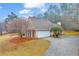 Side view showcasing attached garage, a paved driveway, manicured lawn, and a well-maintained yard at 221 The Esplanade Se Way, Loganville, GA 30052