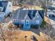 Aerial view of a charming home with blue accents, set among lush trees and neighboring houses at 449 South Hill St., Buford, GA 30518